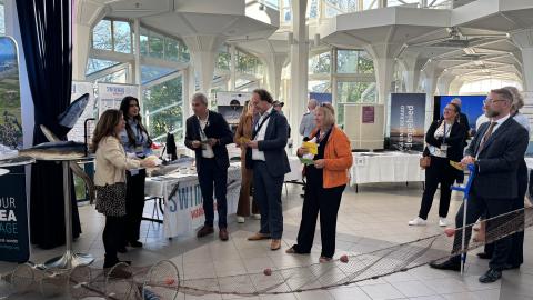 Swimway Expert Group members and ministers from the trilateral countries standing by the Swimway marketplace stall for the ministers event. 